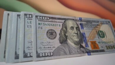 a stack of twenty dollar bills sitting on top of a table