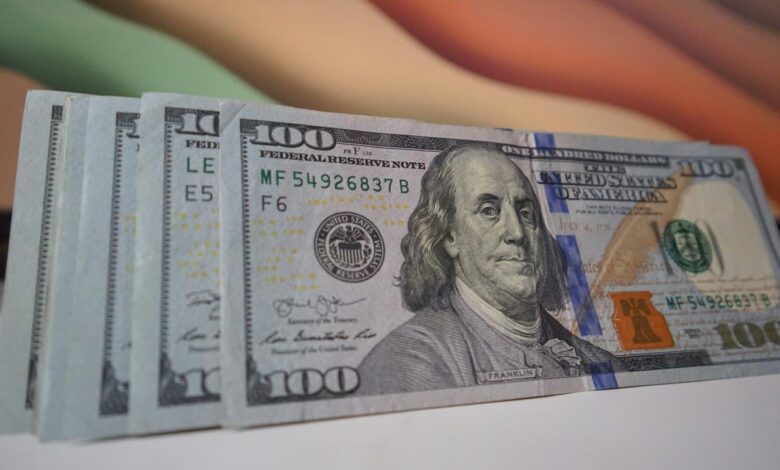 a stack of twenty dollar bills sitting on top of a table