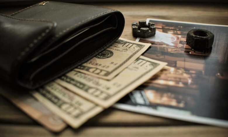 black leather bifold wallet on banknotes