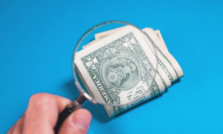 Magnifying glass over folded us dollar bills
